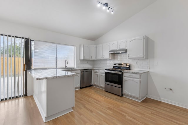 kitchen featuring appliances with stainless steel finishes, sink, white cabinets, decorative backsplash, and light hardwood / wood-style floors