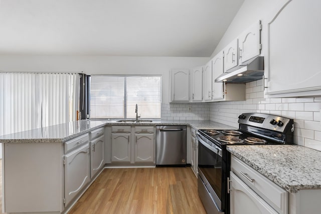 kitchen featuring sink, white cabinetry, light wood-type flooring, appliances with stainless steel finishes, and backsplash