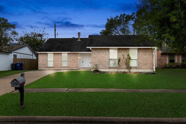 ranch-style home with a yard