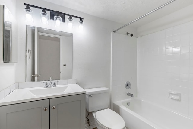 full bathroom with vanity, tiled shower / bath combo, toilet, and a textured ceiling