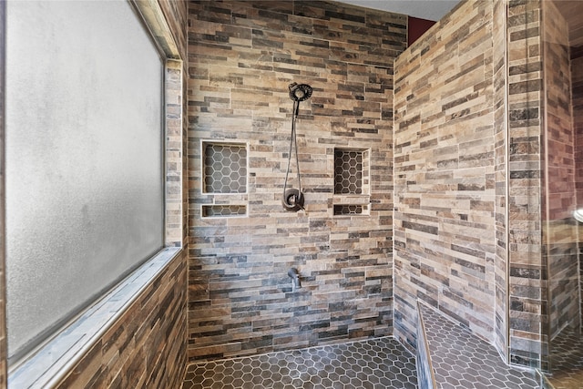 bathroom with tile patterned floors and a tile shower