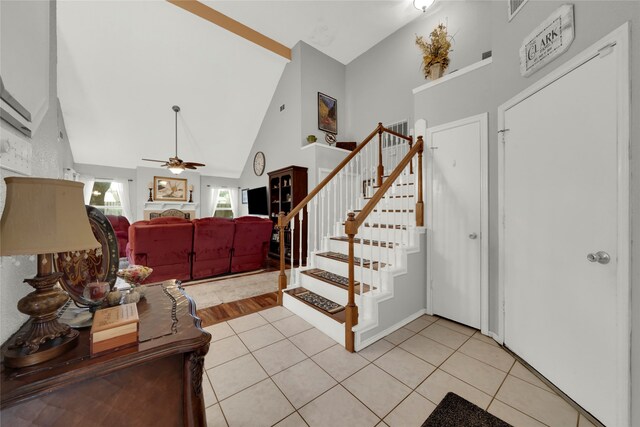 tiled entryway featuring high vaulted ceiling and ceiling fan