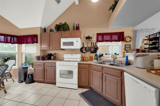 kitchen with light tile patterned floors, white appliances, sink, and high vaulted ceiling