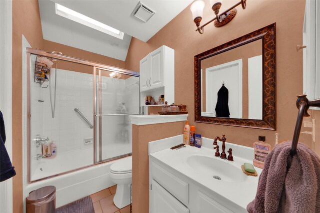 full bathroom featuring vanity, bath / shower combo with glass door, tile patterned flooring, toilet, and lofted ceiling