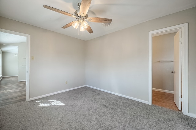 unfurnished room with ceiling fan and carpet