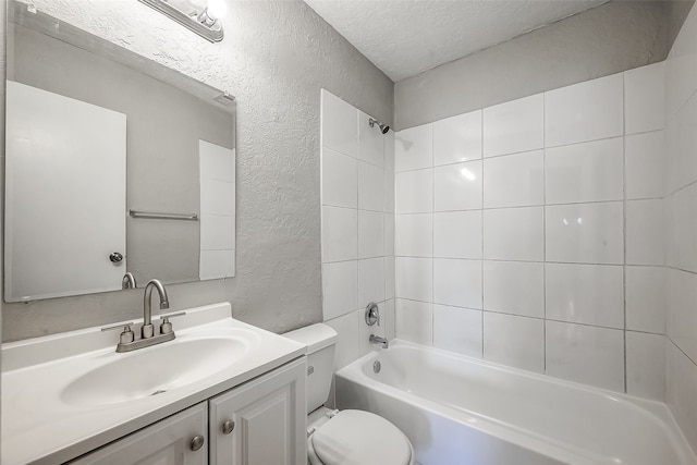 full bathroom featuring a textured ceiling, toilet, vanity, and tiled shower / bath