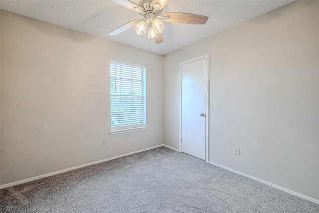 empty room with ceiling fan, carpet, and a textured ceiling