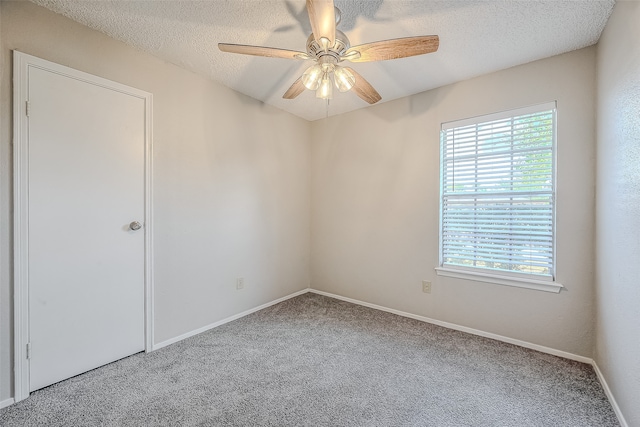 carpeted spare room with ceiling fan and a textured ceiling