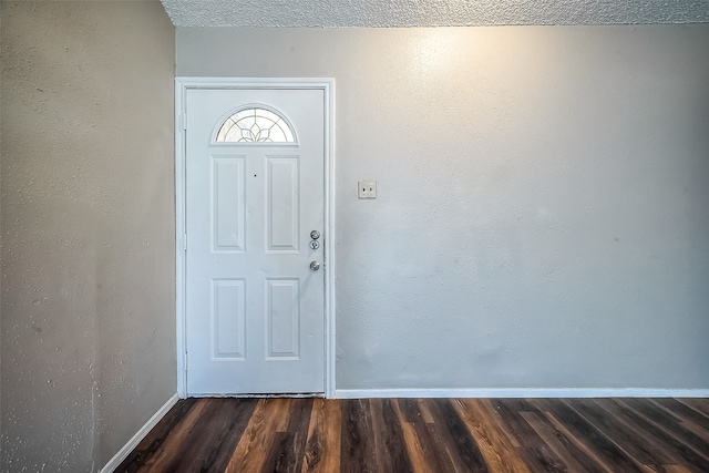 entrance foyer featuring a textured ceiling and dark hardwood / wood-style flooring