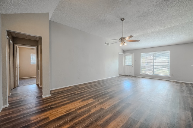 unfurnished room featuring lofted ceiling, ceiling fan, dark wood-type flooring, and a textured ceiling