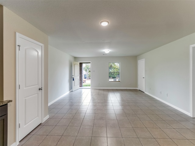 tiled spare room featuring a textured ceiling