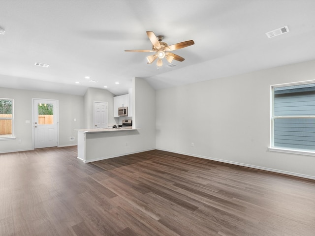 unfurnished living room with dark hardwood / wood-style floors, ceiling fan, and vaulted ceiling