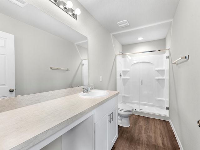 bathroom with vanity, hardwood / wood-style floors, toilet, and walk in shower