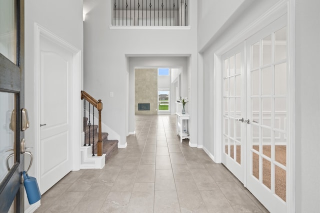 tiled foyer entrance with a high ceiling and french doors