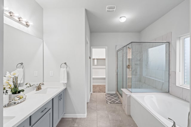 bathroom with vanity, independent shower and bath, a wealth of natural light, and tile patterned flooring