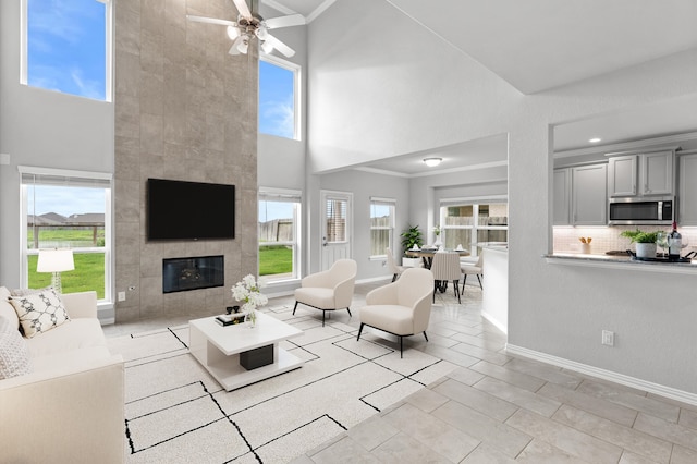 tiled living room with plenty of natural light, a high ceiling, and ceiling fan