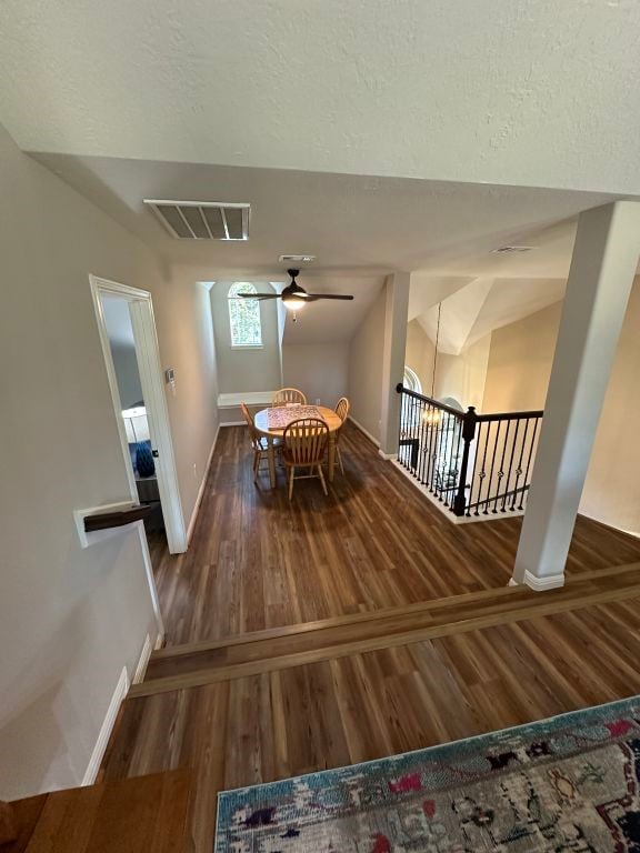 unfurnished dining area with lofted ceiling, ceiling fan, and dark hardwood / wood-style flooring