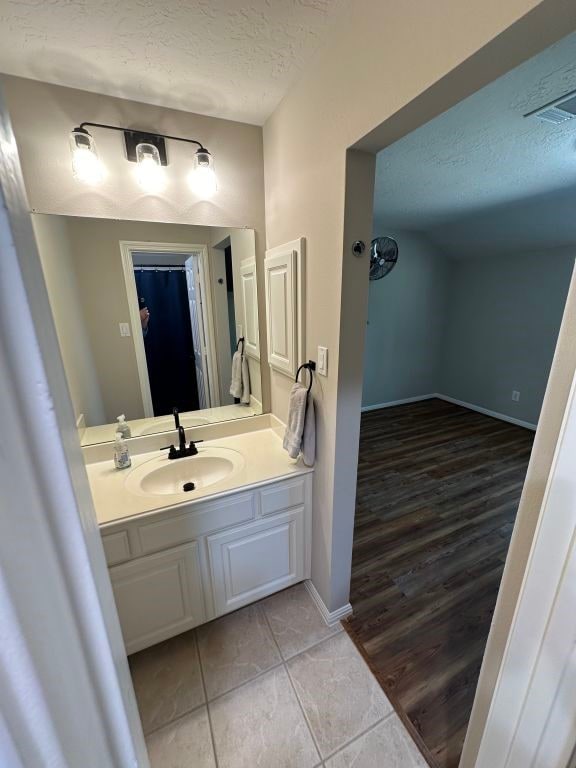 bathroom with vanity, hardwood / wood-style floors, and a textured ceiling