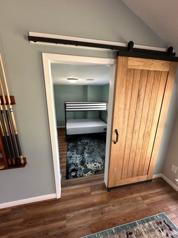 interior space with a barn door and dark hardwood / wood-style flooring