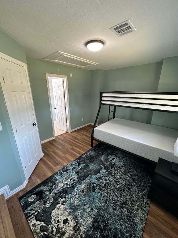 bedroom with dark wood-type flooring and a textured ceiling