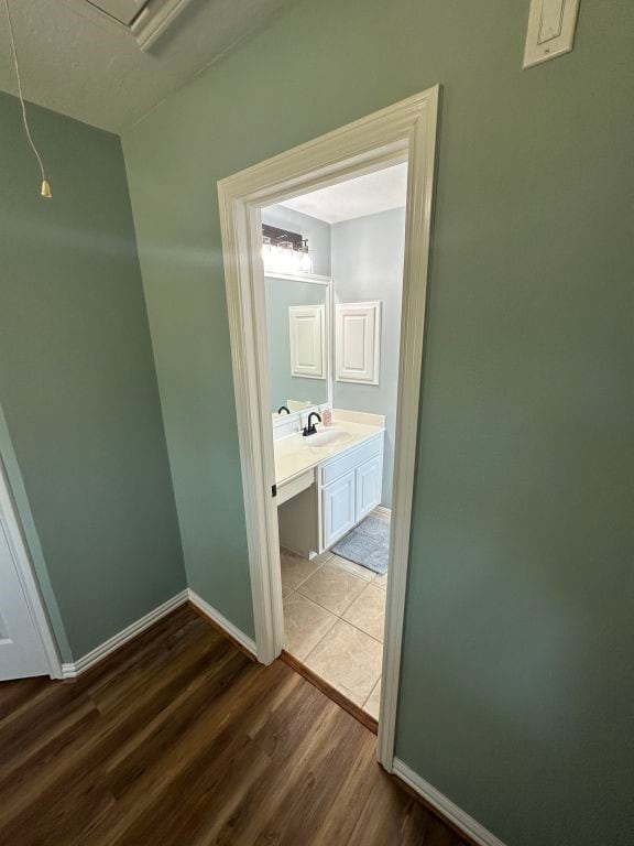 hallway with sink and light wood-type flooring