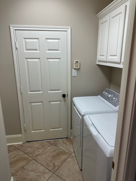 washroom featuring cabinets, light tile patterned flooring, and separate washer and dryer