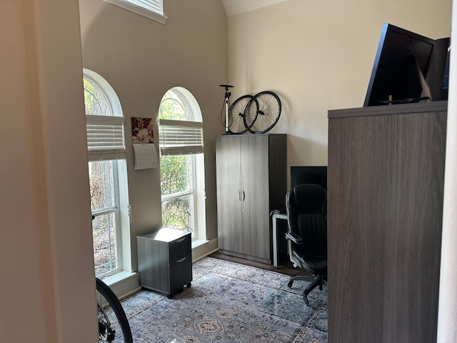 home office with vaulted ceiling and light hardwood / wood-style floors