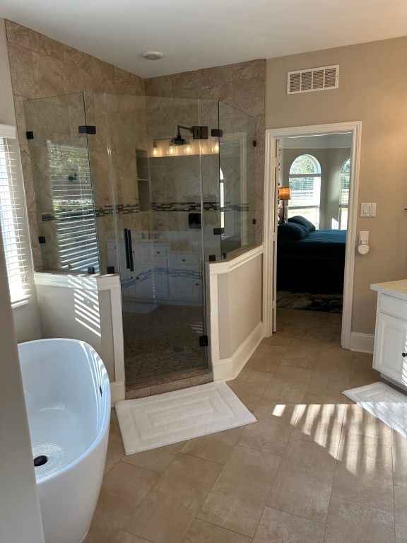 bathroom featuring vanity, independent shower and bath, and tile patterned floors