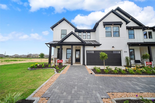 modern inspired farmhouse with a front lawn and a garage