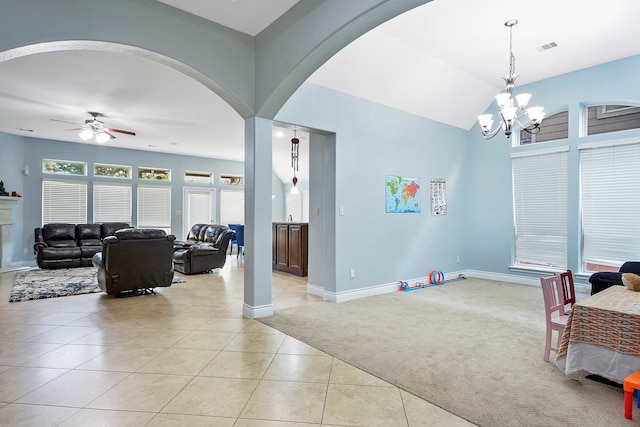 living room featuring light colored carpet and ceiling fan with notable chandelier