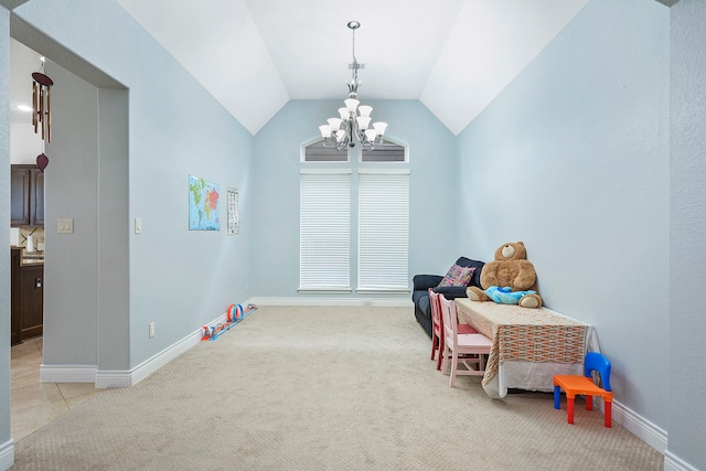 recreation room featuring an inviting chandelier, vaulted ceiling, light carpet, and a healthy amount of sunlight