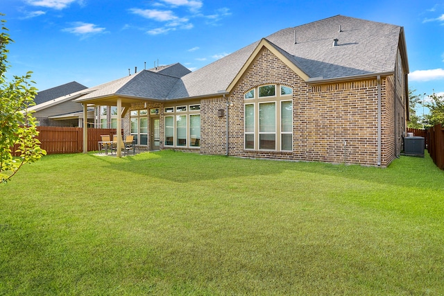 rear view of property featuring a patio, central air condition unit, and a lawn