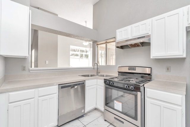 kitchen with range hood, sink, white cabinetry, appliances with stainless steel finishes, and ceiling fan