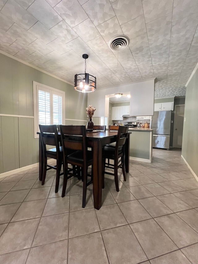 dining room featuring light tile patterned flooring and ornamental molding