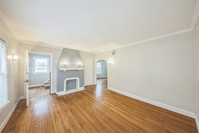 unfurnished living room with wood-type flooring and ornamental molding