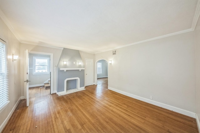 2409 Arbor St, Houston, TX 77004 - unfurnished living room with arched walkways, light wood-type flooring, baseboards, and crown molding