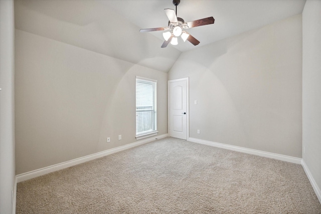 empty room with carpet flooring, ceiling fan, and vaulted ceiling