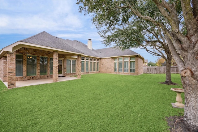 rear view of property featuring a patio and a lawn