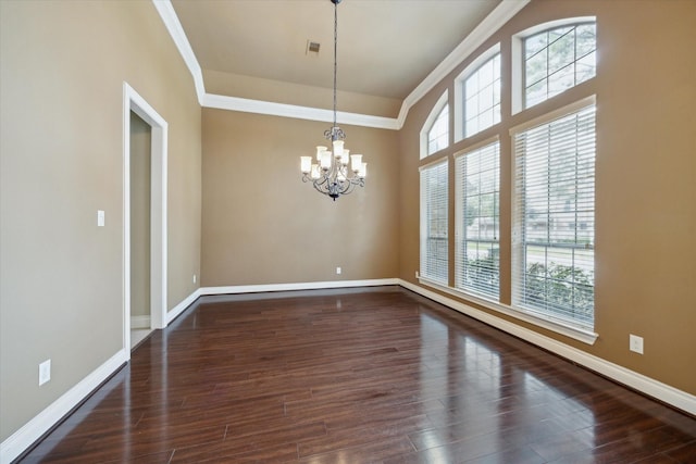 unfurnished room featuring crown molding, dark wood-type flooring, and a notable chandelier