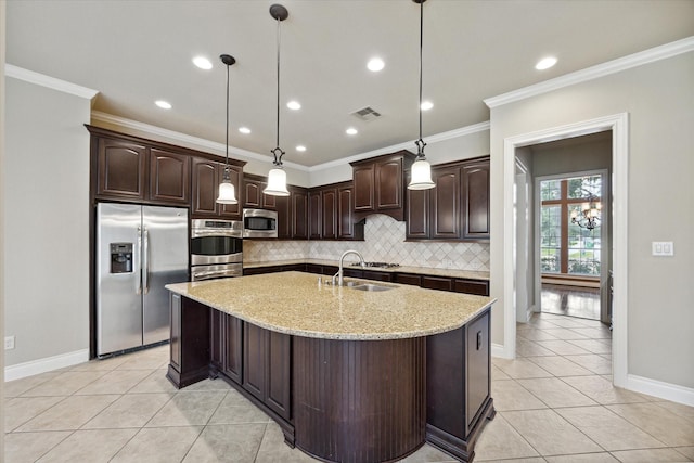 kitchen featuring dark brown cabinetry, light stone countertops, sink, hanging light fixtures, and stainless steel appliances