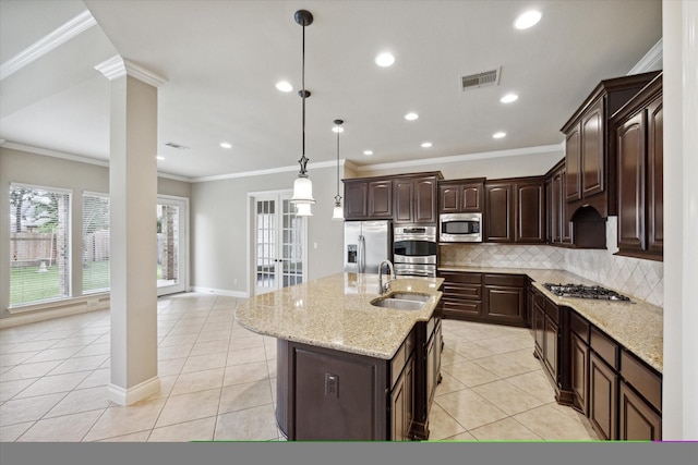 kitchen with dark brown cabinetry, a kitchen island with sink, light tile patterned floors, and stainless steel appliances