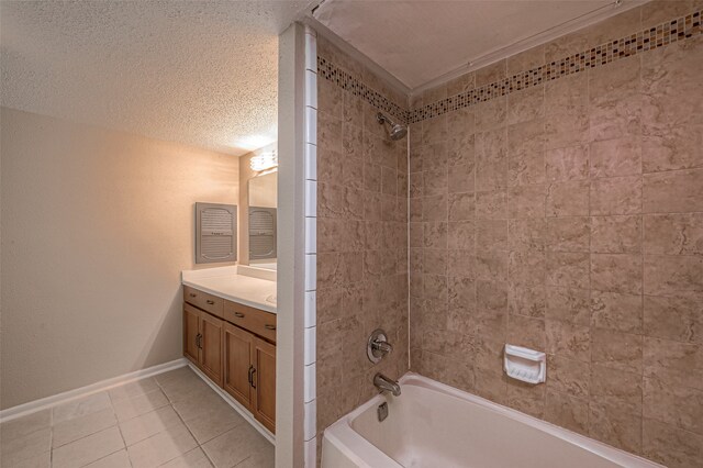 bathroom with tile patterned flooring, vanity, a textured ceiling, and tiled shower / bath