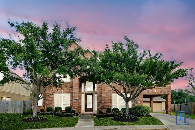 view of front of house with a garage and a yard