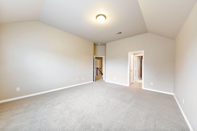 carpeted spare room featuring lofted ceiling