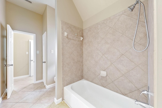 bathroom with tile patterned flooring, toilet, and tiled shower / bath