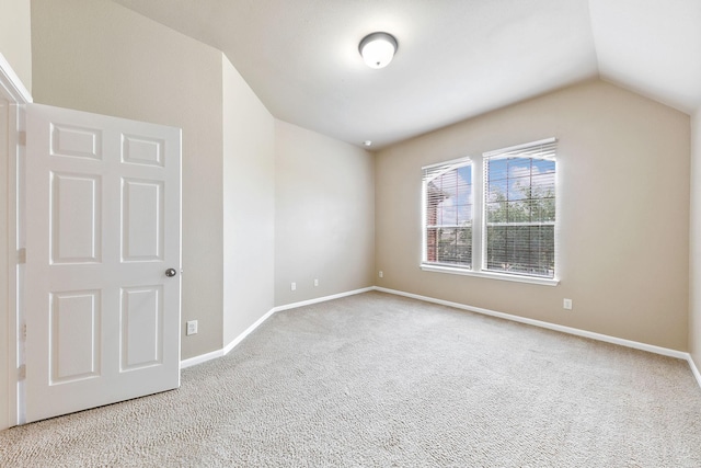 unfurnished room with light carpet and lofted ceiling