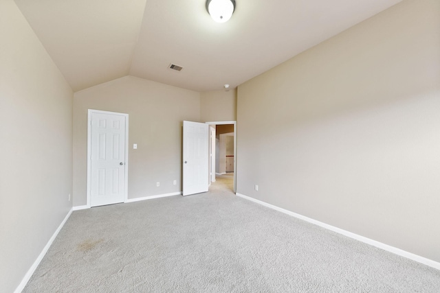 unfurnished bedroom with light carpet and lofted ceiling