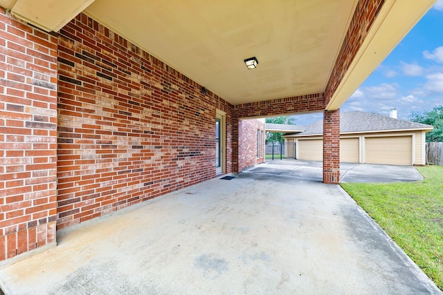 view of patio with a garage and an outbuilding