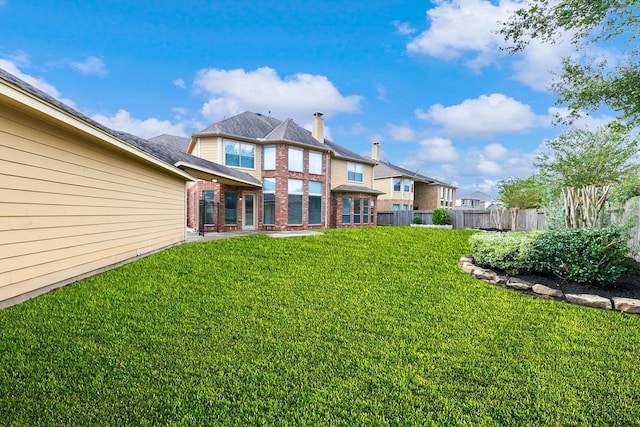 rear view of property with a yard