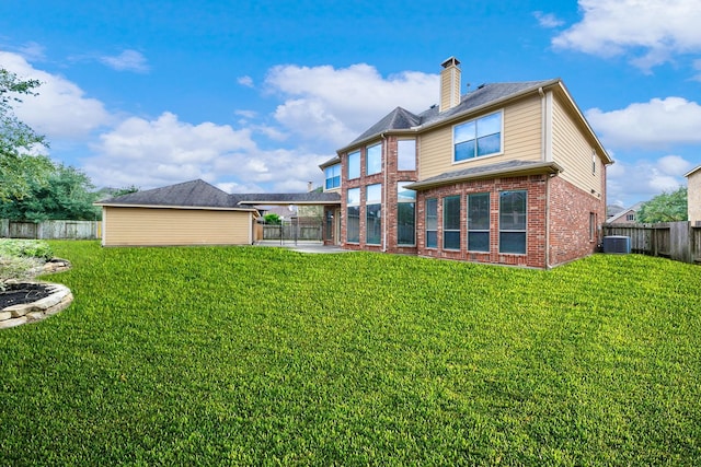 rear view of property with central AC and a yard